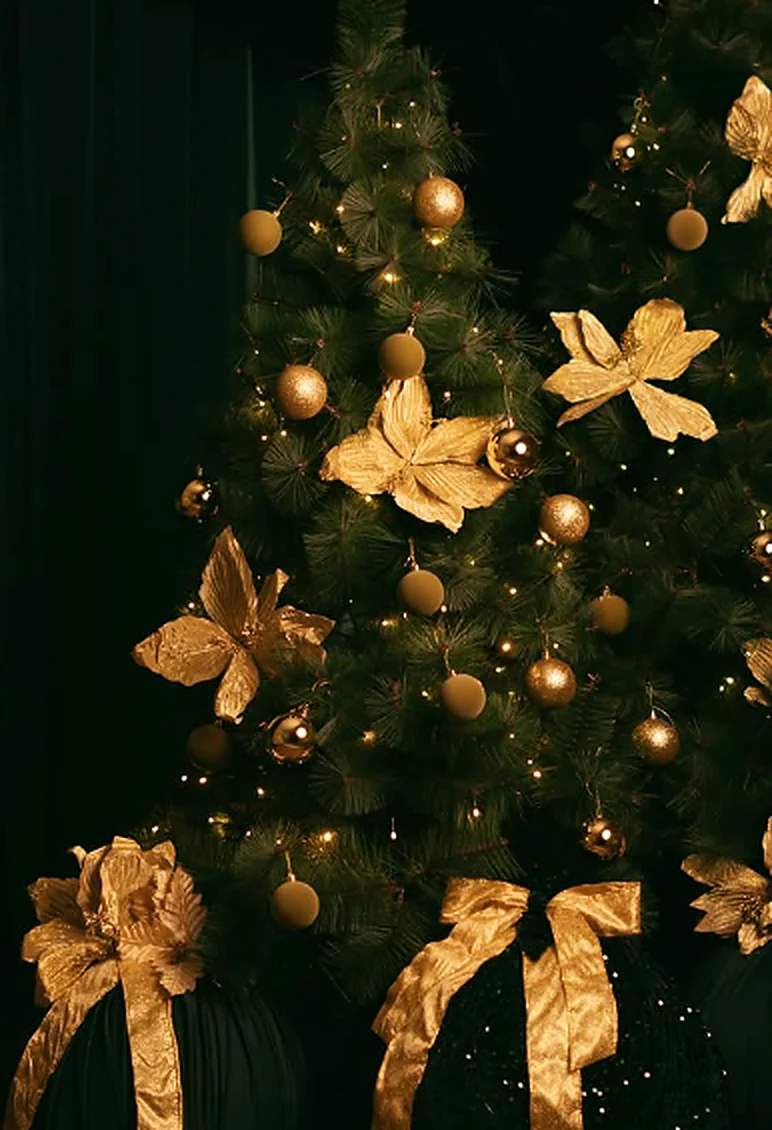 Árvore de Natal em cenário verde-escuro decorada com laços e bolas douradas